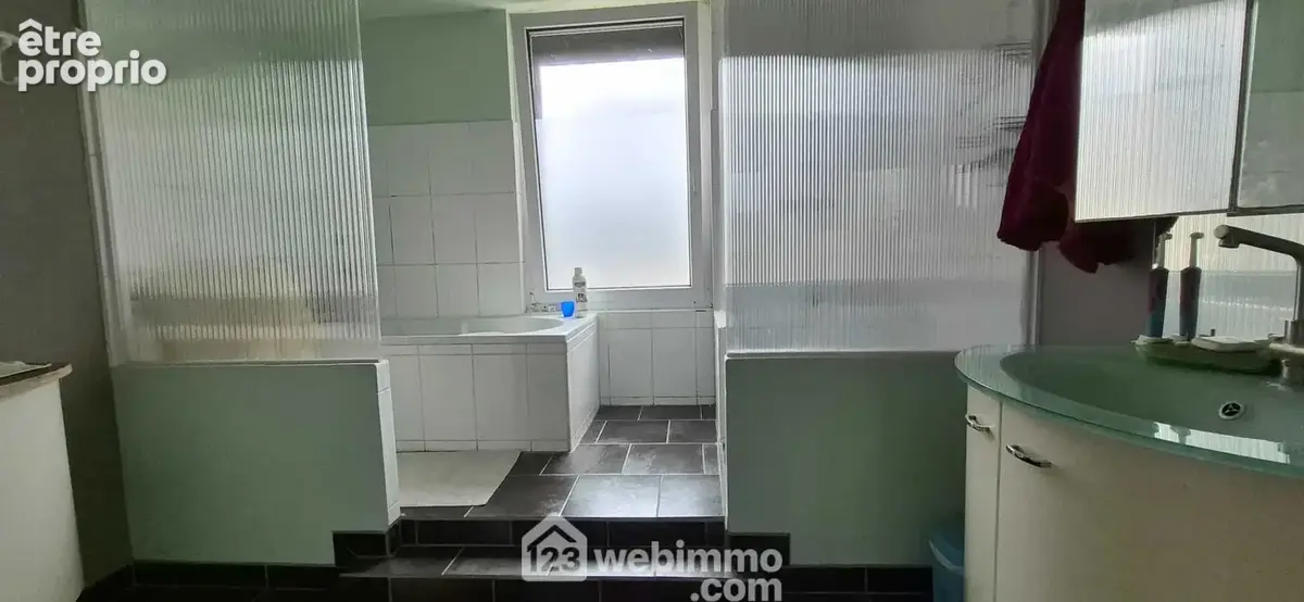Une salle de bains de 12 m² avec baignoire, douche et vasque sur meuble