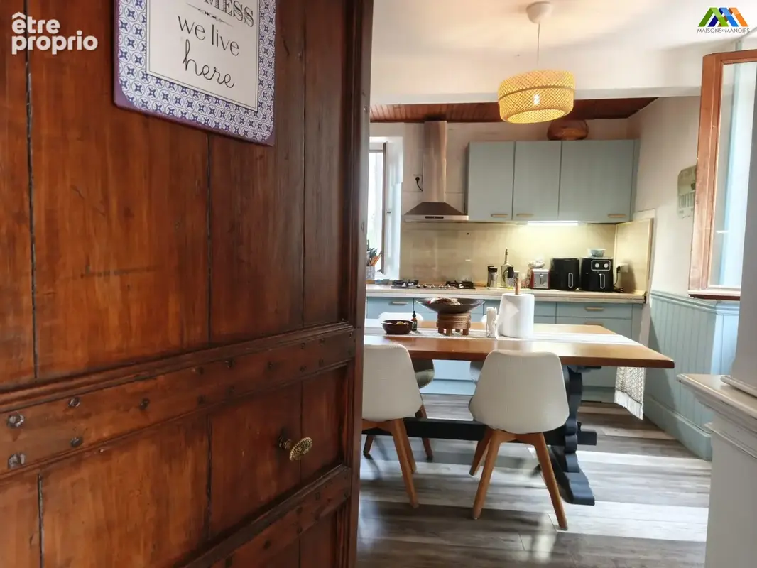 Espace repas lumineux avec vue sur la cuisine et accès au séjour