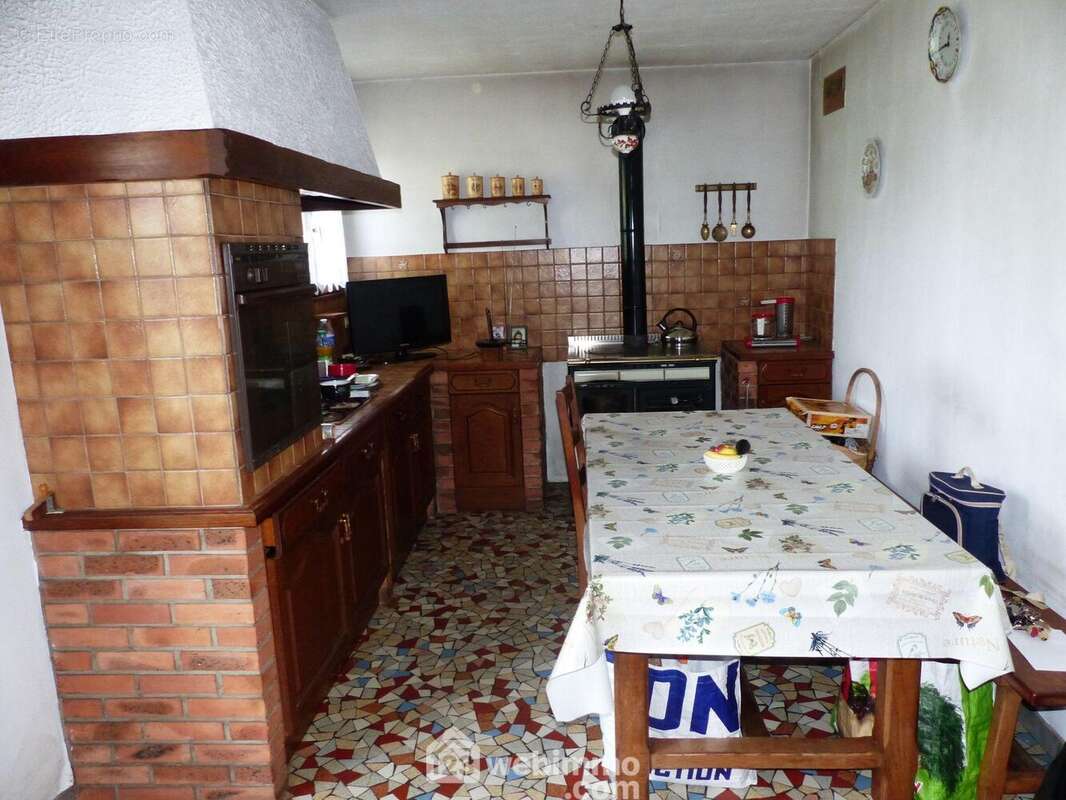 Cuisine aménagée et équipée de 16 m2 avec sa cuisinière à bois. - Maison à FONTAINE-LE-BOURG