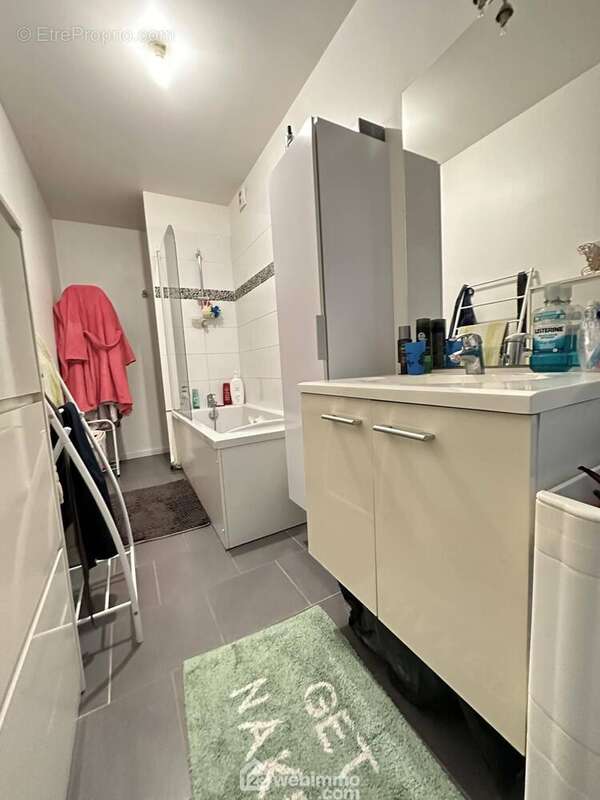 La salle de bains avec double vasque sur meuble et une baignoire/douche