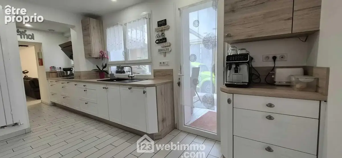 La cuisine ouverte de 15 m² équipée et très fonctionnelle, avec accès sur ...