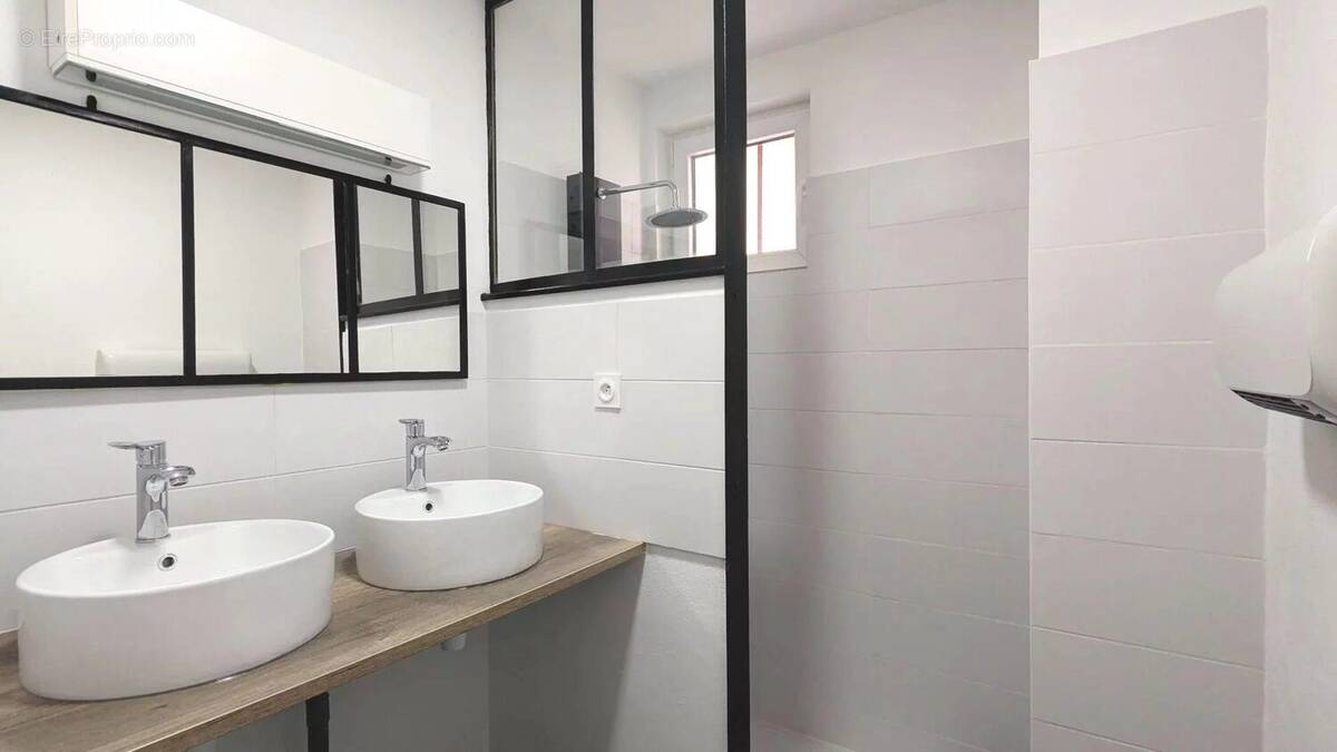 Une salle de bain moderne avec deux lavabos, des miroirs et une douche à l'italienne. - Maison à DOLMAYRAC