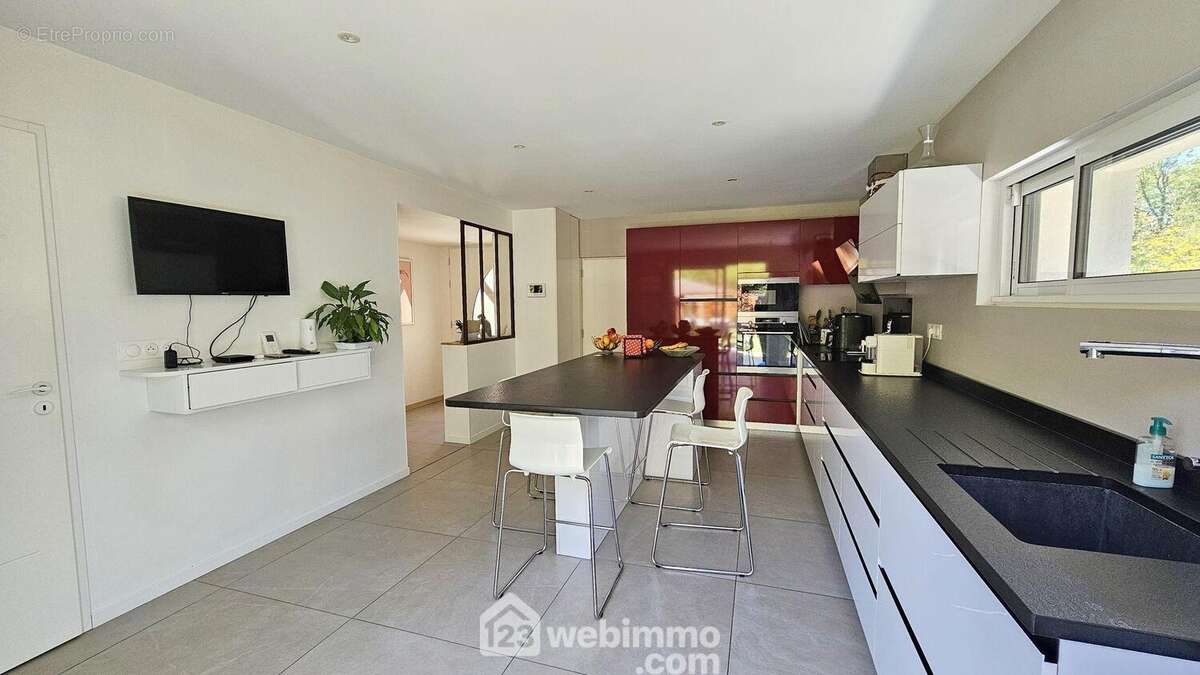 Une cuisine fonctionnelle avec son espace repas. - Maison à NOISY-SUR-ECOLE