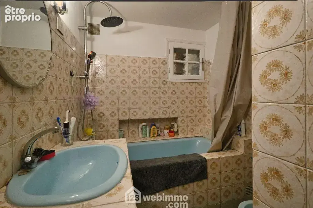Depuis la cuisine, une salle de bains à rafraîchir, un WC et une buanderie.