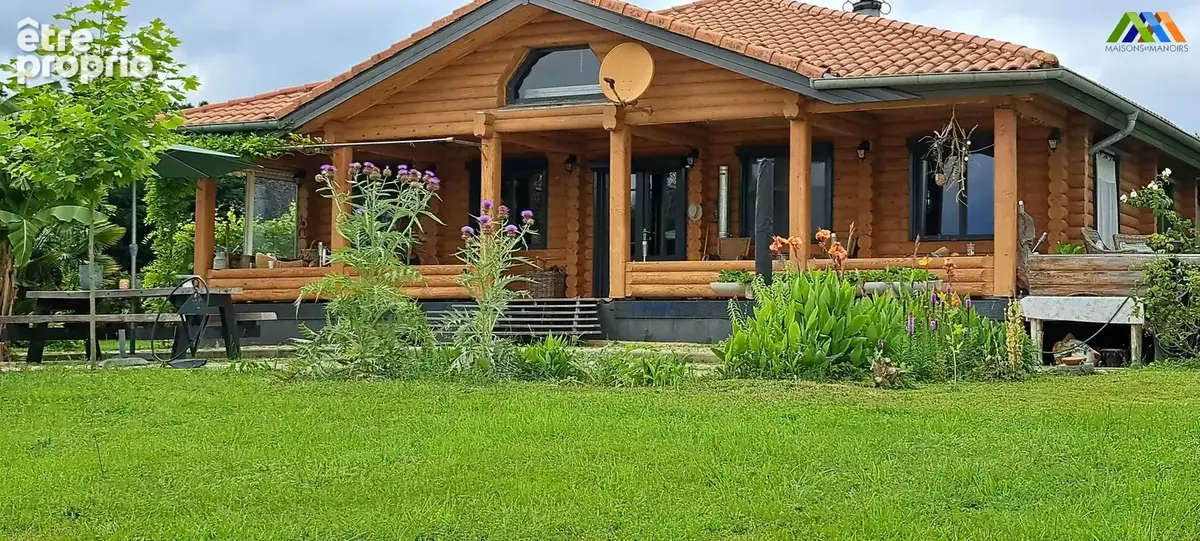 Chalet en bois avec terrasse couverte et jardin verdoyant. - Maison à TRIE-SUR-BAISE