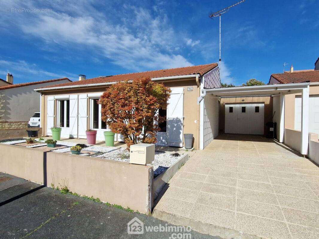 Façade côté rue avec carport et garage. - Maison à LA ROCHE-SUR-YON