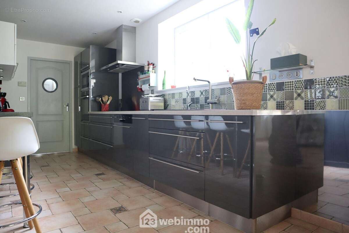 Ouverte, la cuisine de 11 m2 est aménagée et équipée. - Maison à QUEAUX