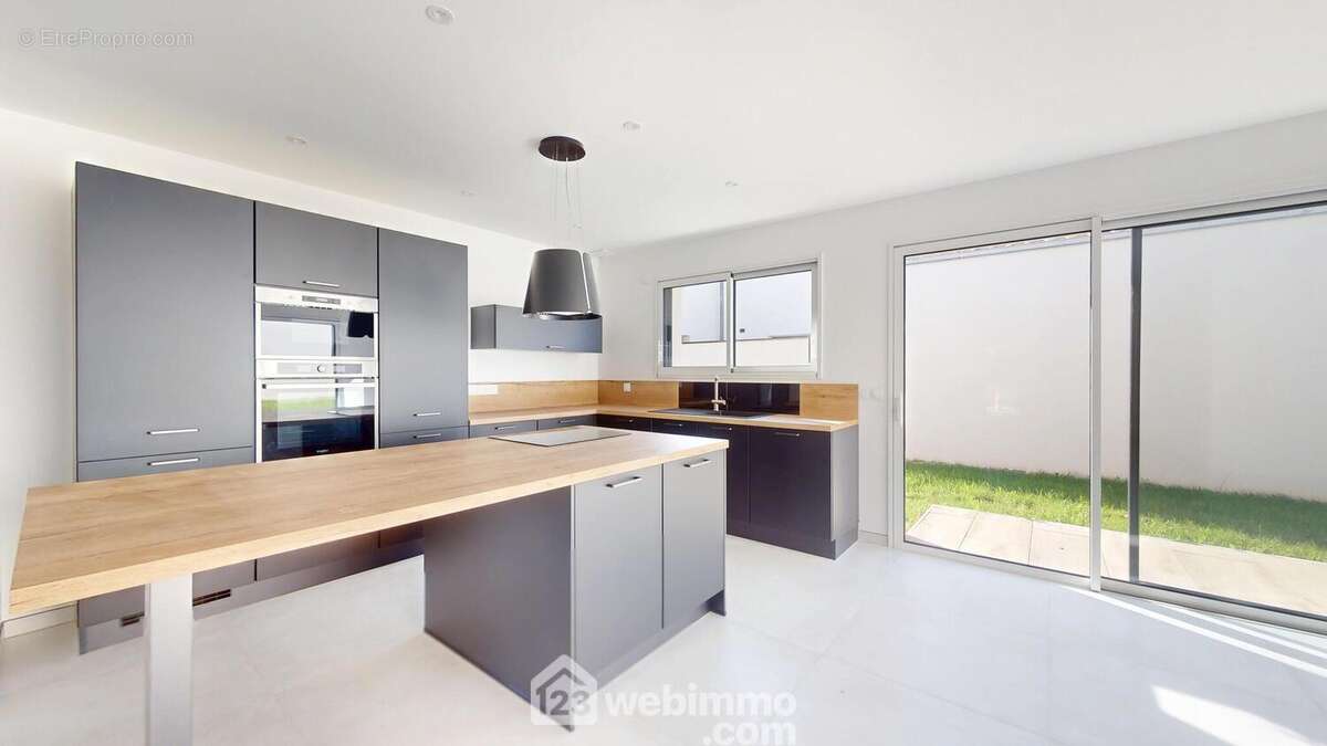 Cuisine équipée ouverte sur le salon. - Maison à SAINT-HILAIRE-LA-FORET