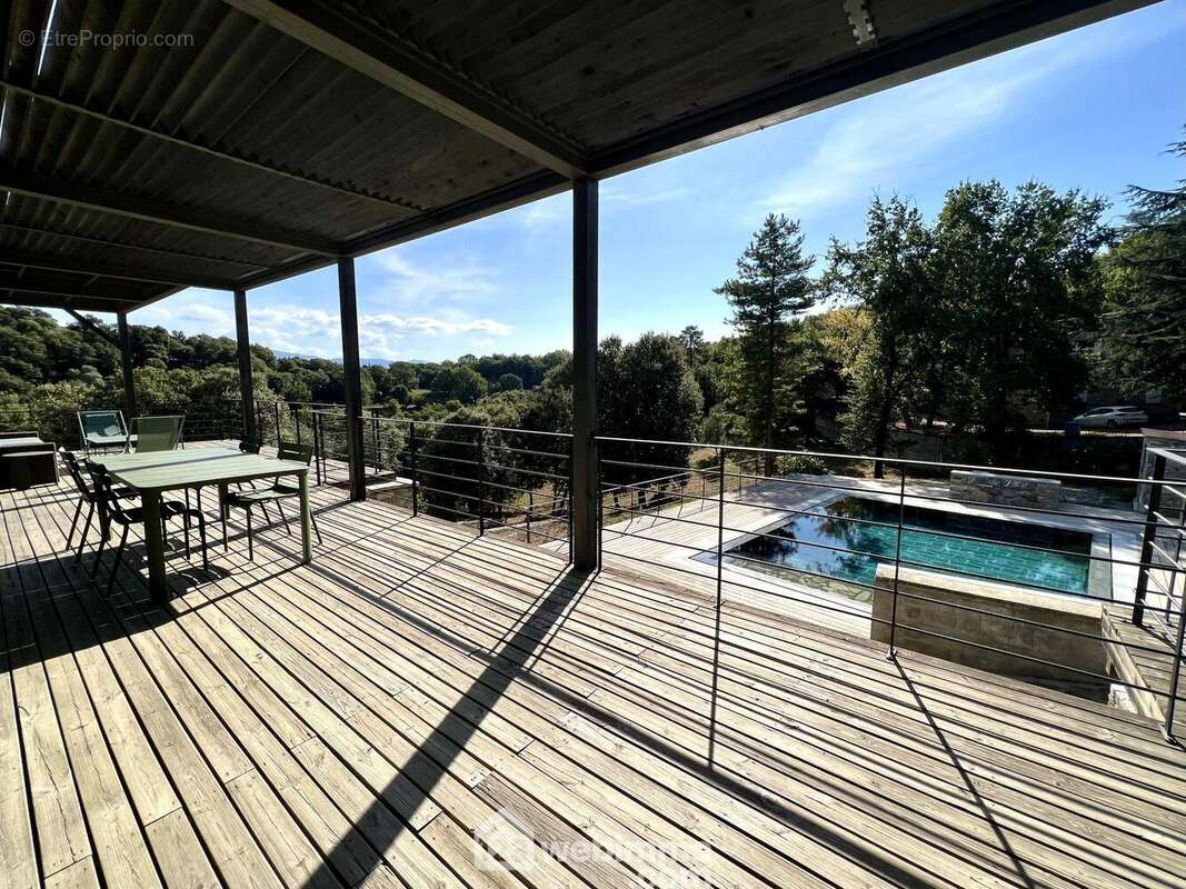 Un espace terrasse couverte qui surplombe la piscine - Maison à CORTE