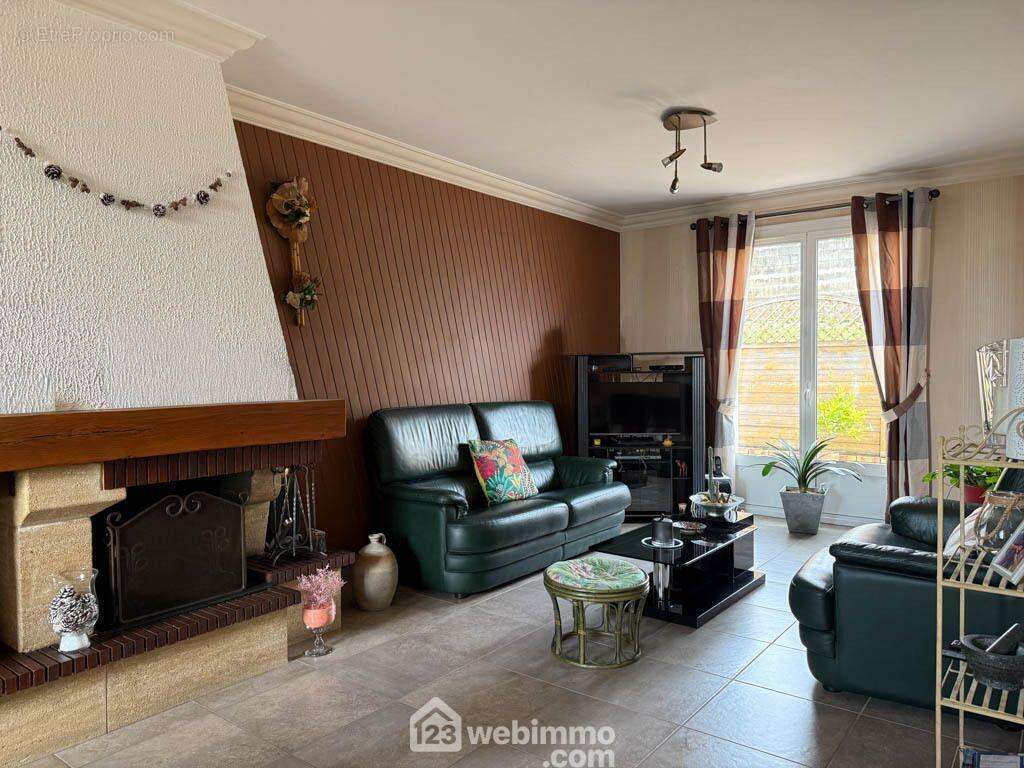 et un coin salon avec cheminée. - Maison à POUZAUGES