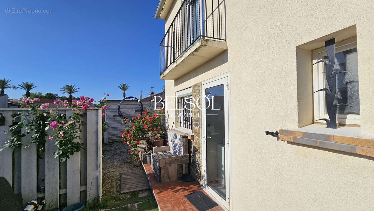 face de la maison avec son entrée fleurie, accès terrasse et piscine