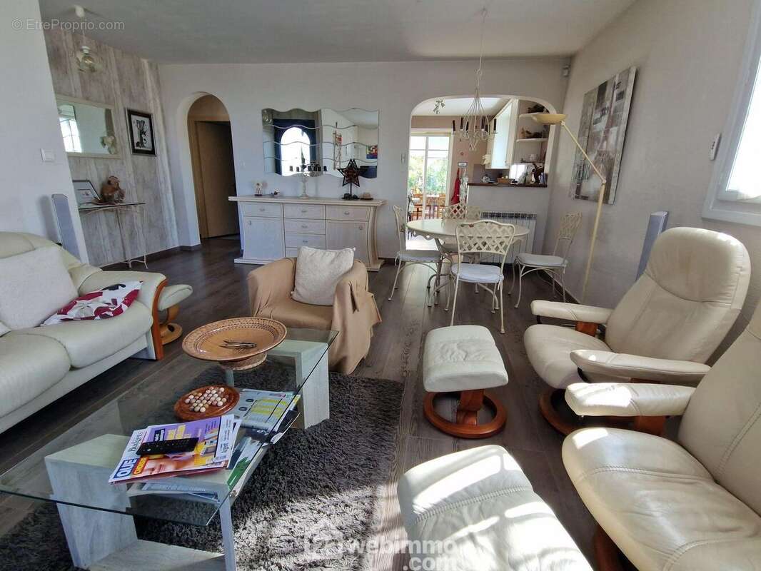 Pièce de vie avec cuisine et accès véranda au second plan - Maison à LA ROCHE-SUR-YON