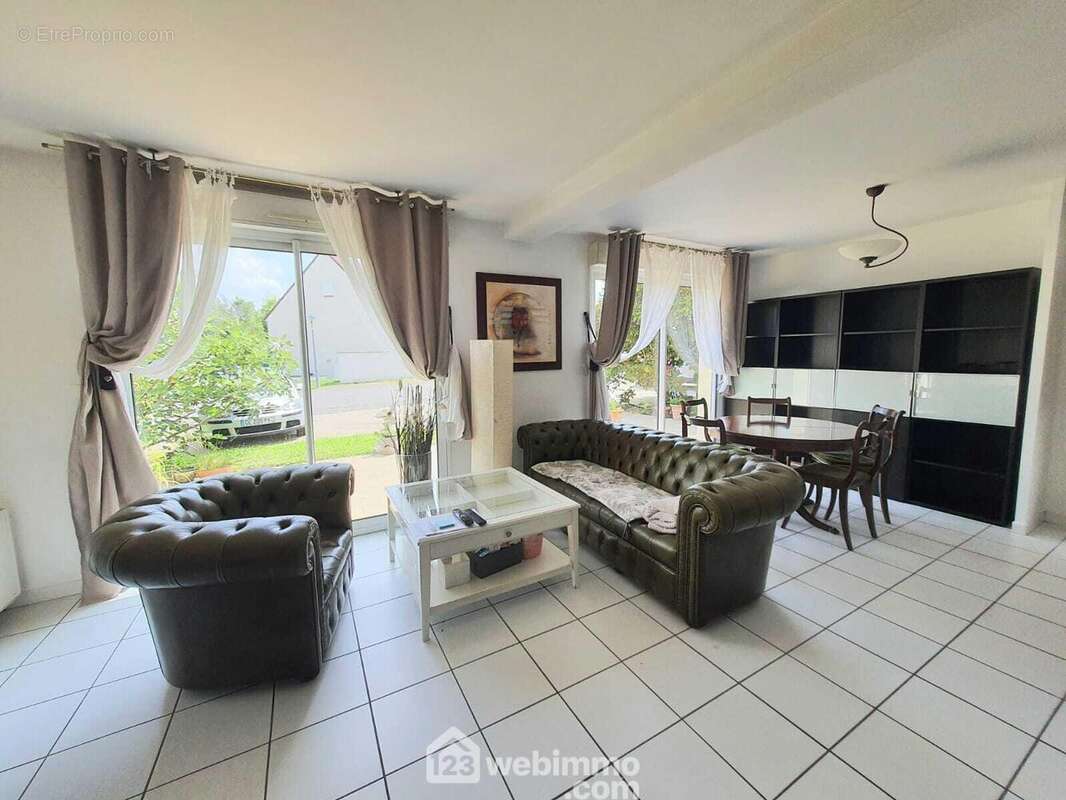 Un séjour lumineux de 42 m² et un accès sur la terrasse. - Maison à DAMMARIE-LES-LYS