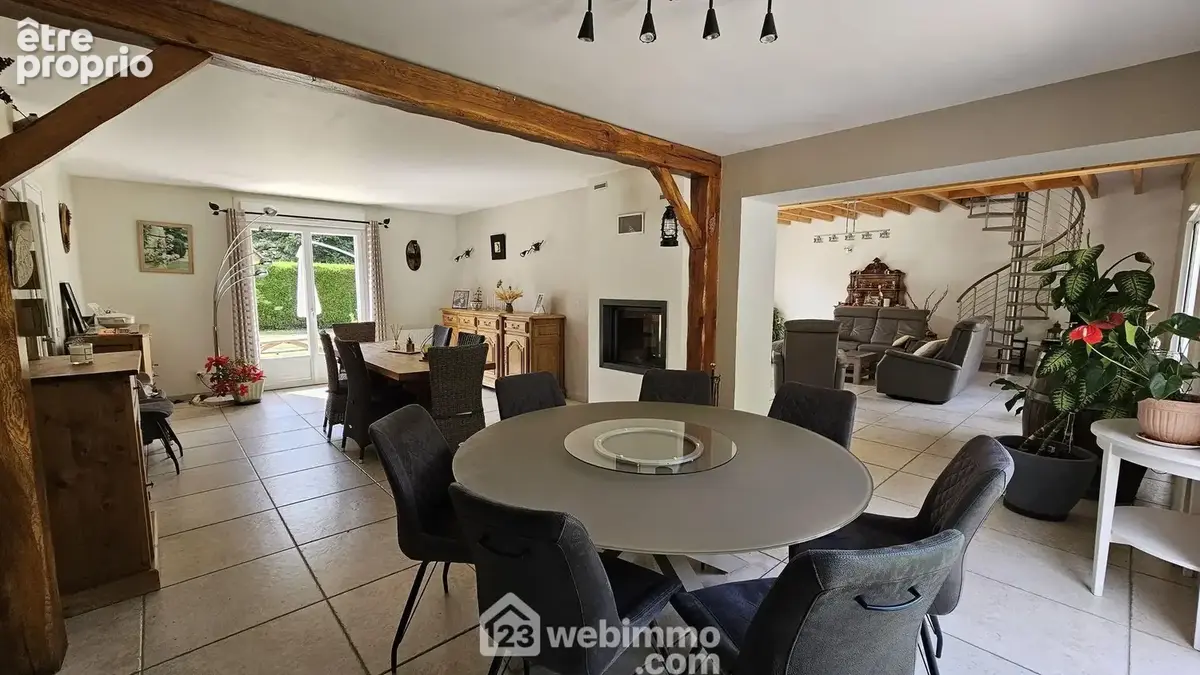 Une salle à manger de 34 m² traversante avec sa cheminée insert à double foyer.