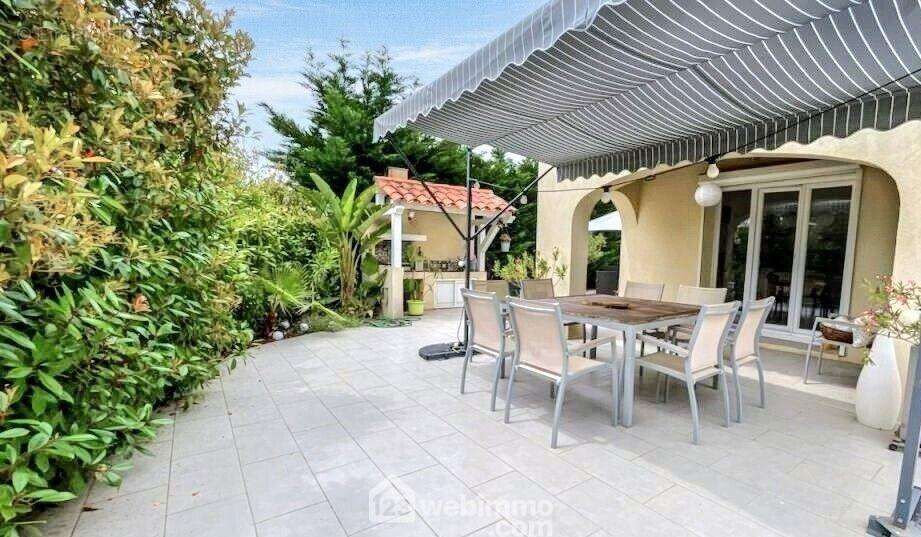 Un véritable espace de vie extérieur, entre intimité et végétation luxuriante, avec espace cuisine d?été couvert, idéal pour les repas en plein air. - Maison à SAINTE-MAXIME