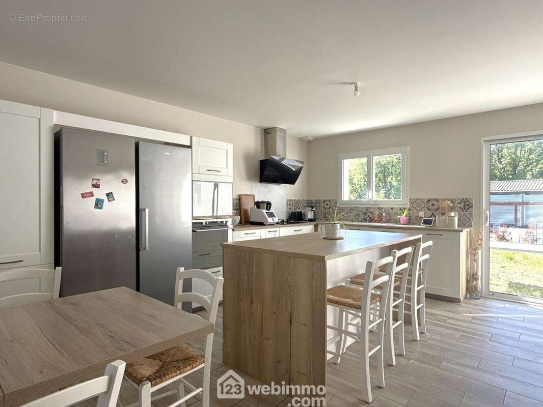 Et cuisine aménagée-équipée ouverte façon US avec coin repas. - Maison à LAVOUX