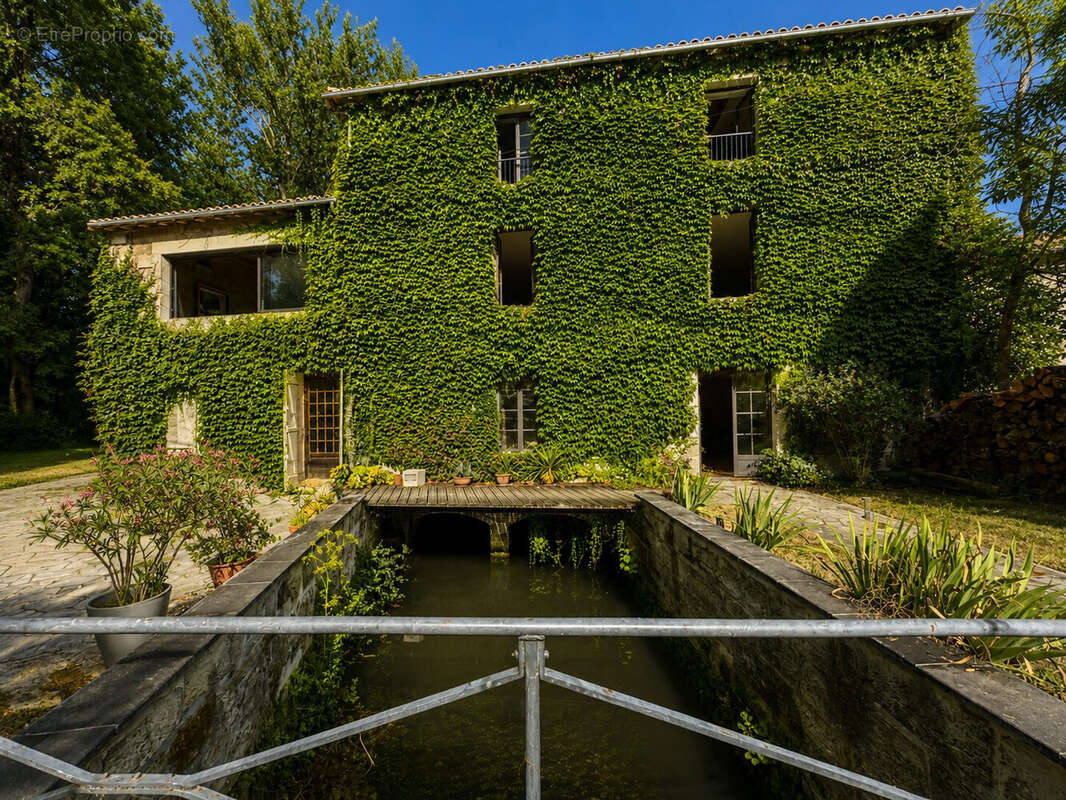 Facade avec pont sur le cours d'eau LE SAP