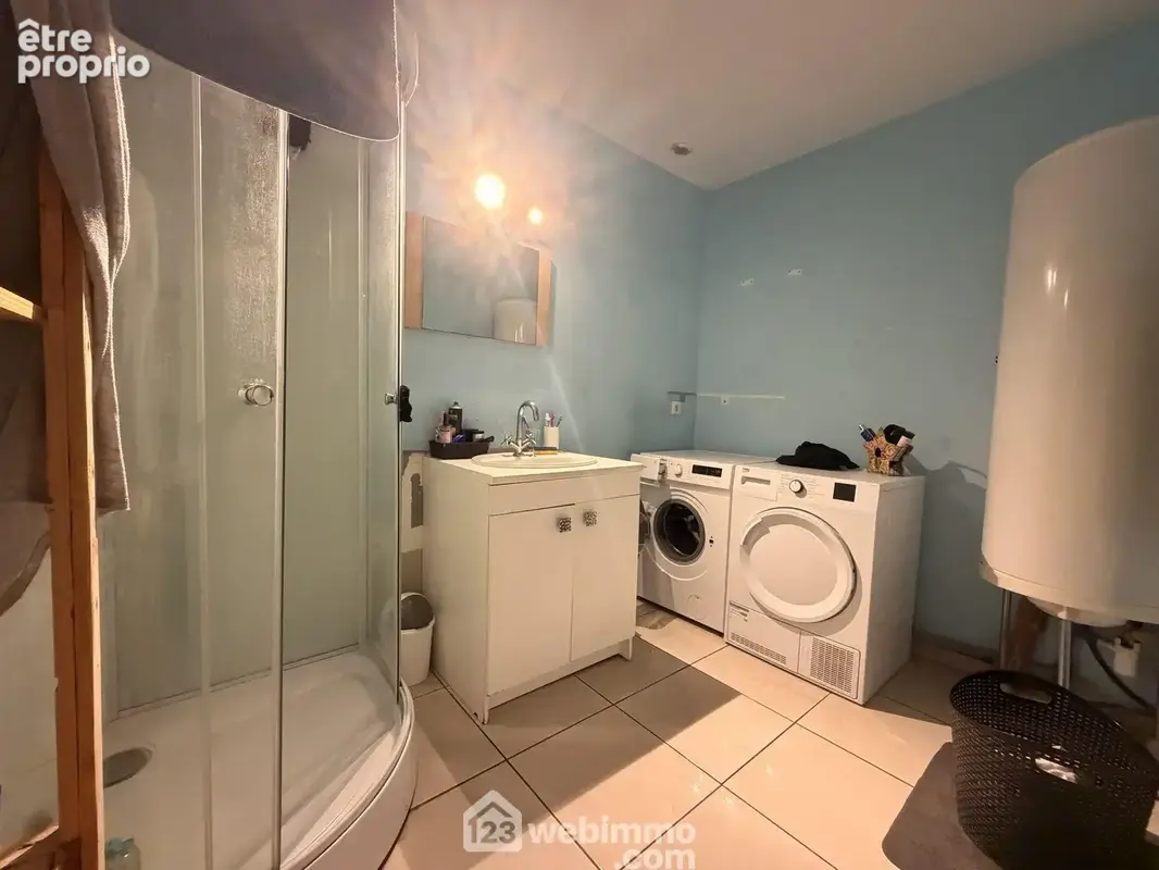La salle de bains avec vasque sur meuble et une douche