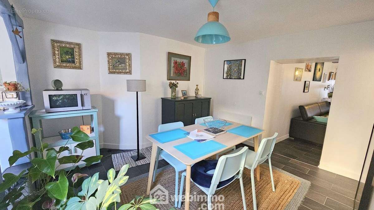 Une salle à manger avec un accès sur la cuisine.