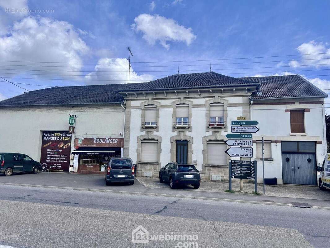Façade avant de l'immeuble qui comprend l'immeuble au milieu avec les 6 ouvertures ainsi que le garage à droite et non la partie boulangerie dont les murs leurs appartiennent - Appartement à BRAS-SUR-MEUSE