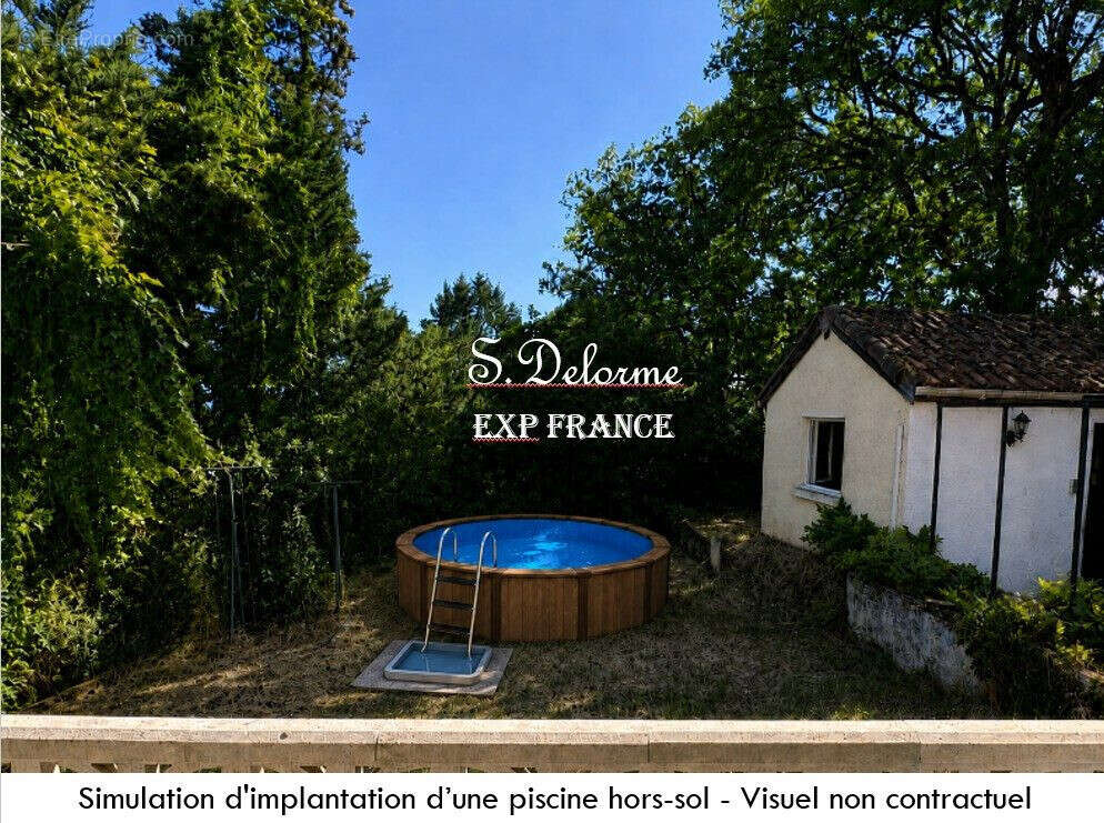 Vue de la porte fenêtre de la cuisine sur le jardin et le cabanon  