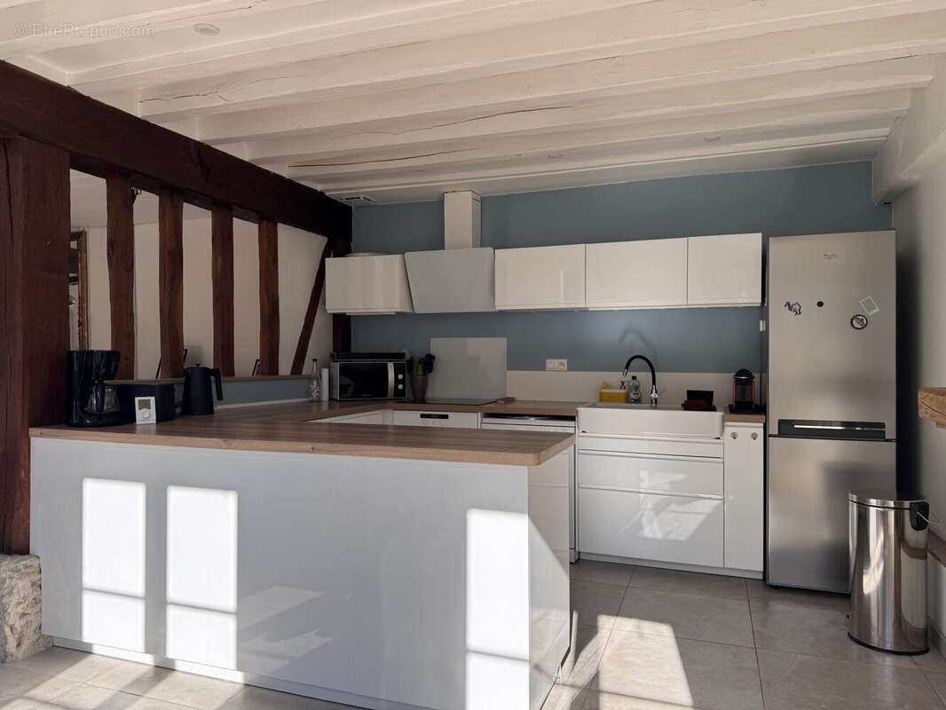 cuisine blanche équipée et ouverte - Maison à CRASVILLE