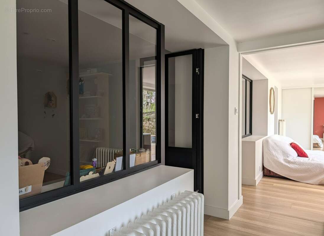 Le couloir du rez-de-jardin avec accès chambre et jardin - Maison à VERTOU