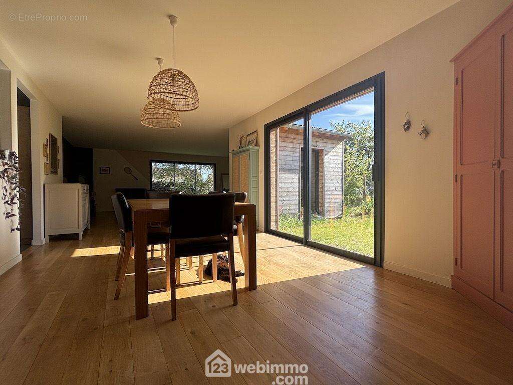 D'un côté, la pièce de vie se déploie sur 74 m2 : - Maison à SAINT-GEORGES-LES-BAILLARGEAUX