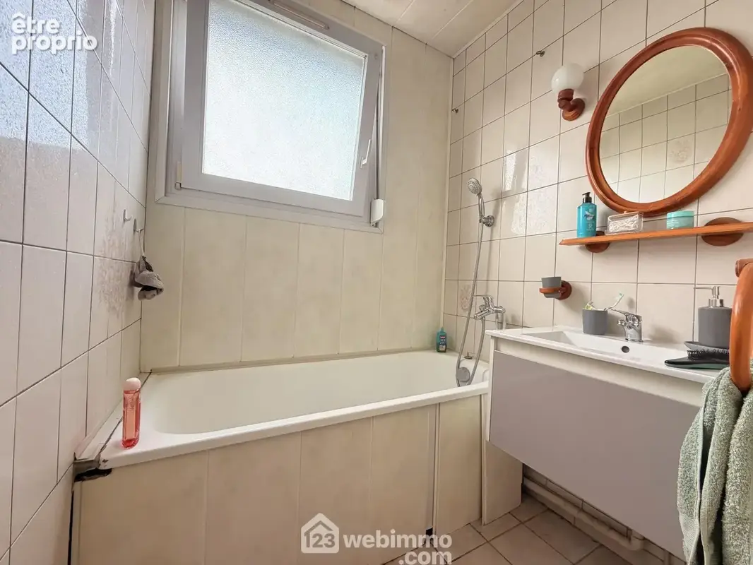 La salle de bains avec vasque sur meuble et une baignoire