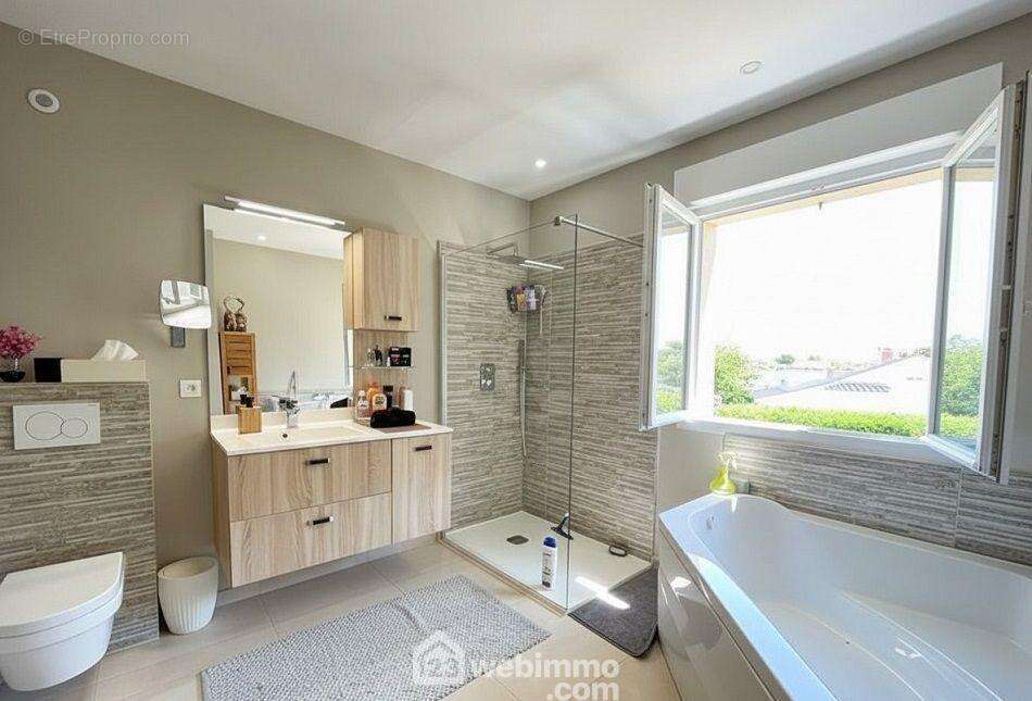 Salle de bains complète avec baignoire et douche, pensée pour le confort quotidien. - Maison à SAINTE-MAXIME