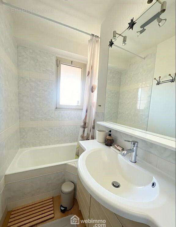 Salle de bains claire, équipée d?une baignoire et d?une fenêtre pour une aération naturelle. - Appartement à SAINTE-MAXIME