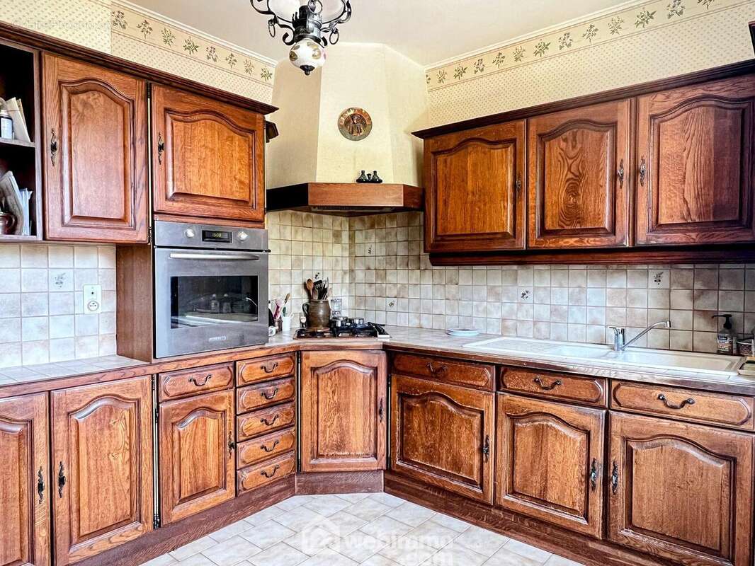 Une cuisine de 11 m² se trouve à proximité de la pièce de vie. - Maison à ANGERS