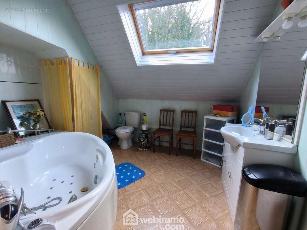 Une salle de bains de 7 m² avec baignoire, vasque sur meuble et WC - Maison à MONT-NOTRE-DAME