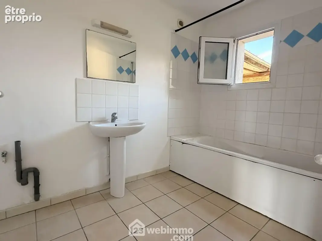 La salle de bains avec lavabo et une baignoire