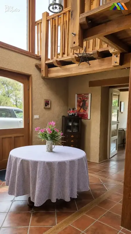 Bright entrance hall with timber gallery and tiled floor.