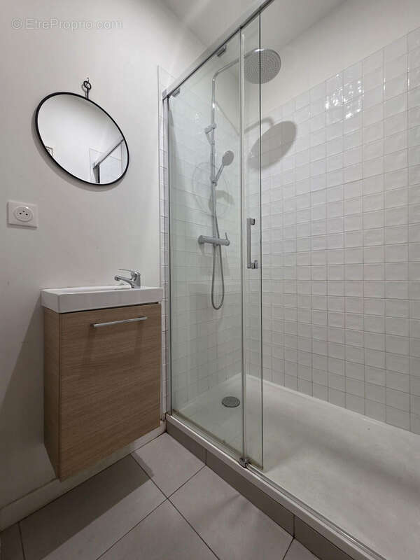 Première salle d?eau moderne, équipée d?une douche spacieuse et d?un aménagement sobre et fonctionnel. - Appartement à REIMS