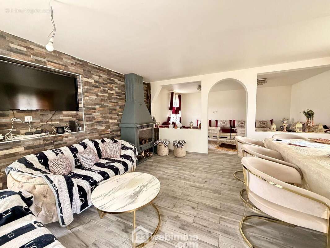 Un salon chaleureux avec cheminée équipée d?un insert, parfait pour profiter de moments cocooning au coin du feu pendant les soirées d?hiver - Maison à VERSIGNY
