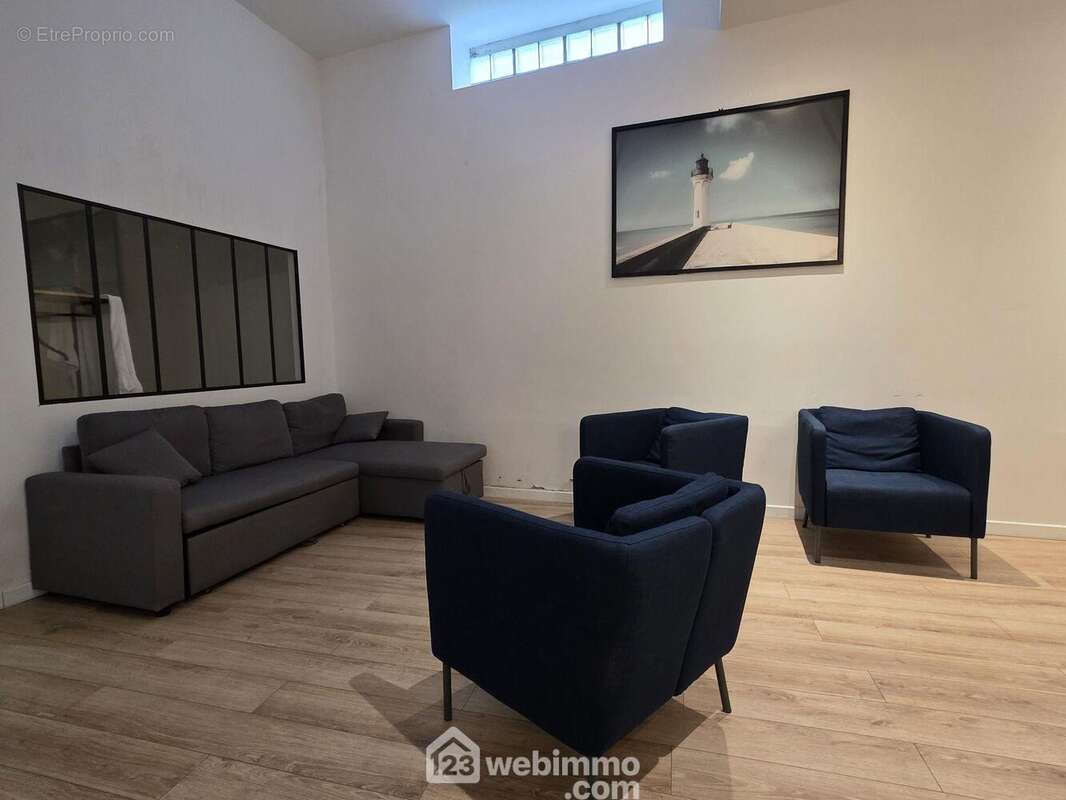 Un salon chaleureux et parfaitement agencé, offrant un espace détente confortable et idéal pour profiter de moments en famille ou entre amis. - Appartement à REIMS