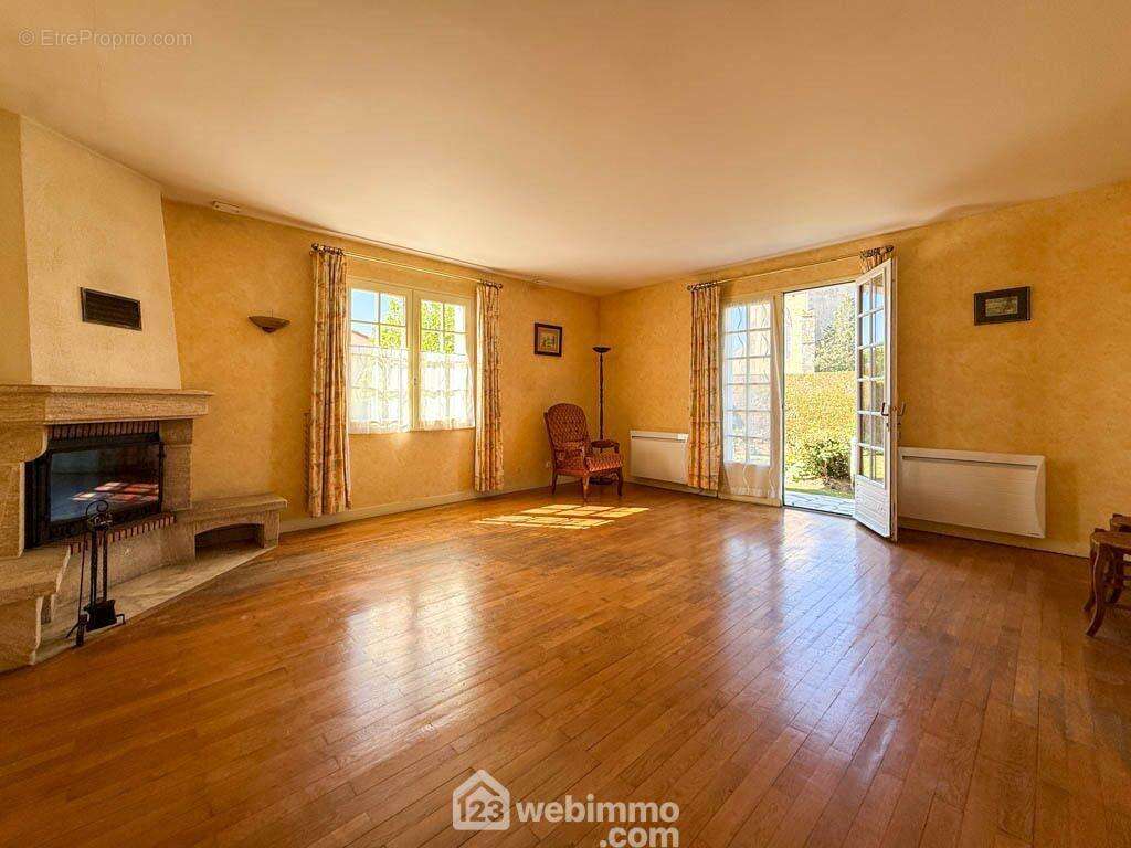 un séjour-salon lumineux avec cheminée insert, - Maison à POUZAUGES