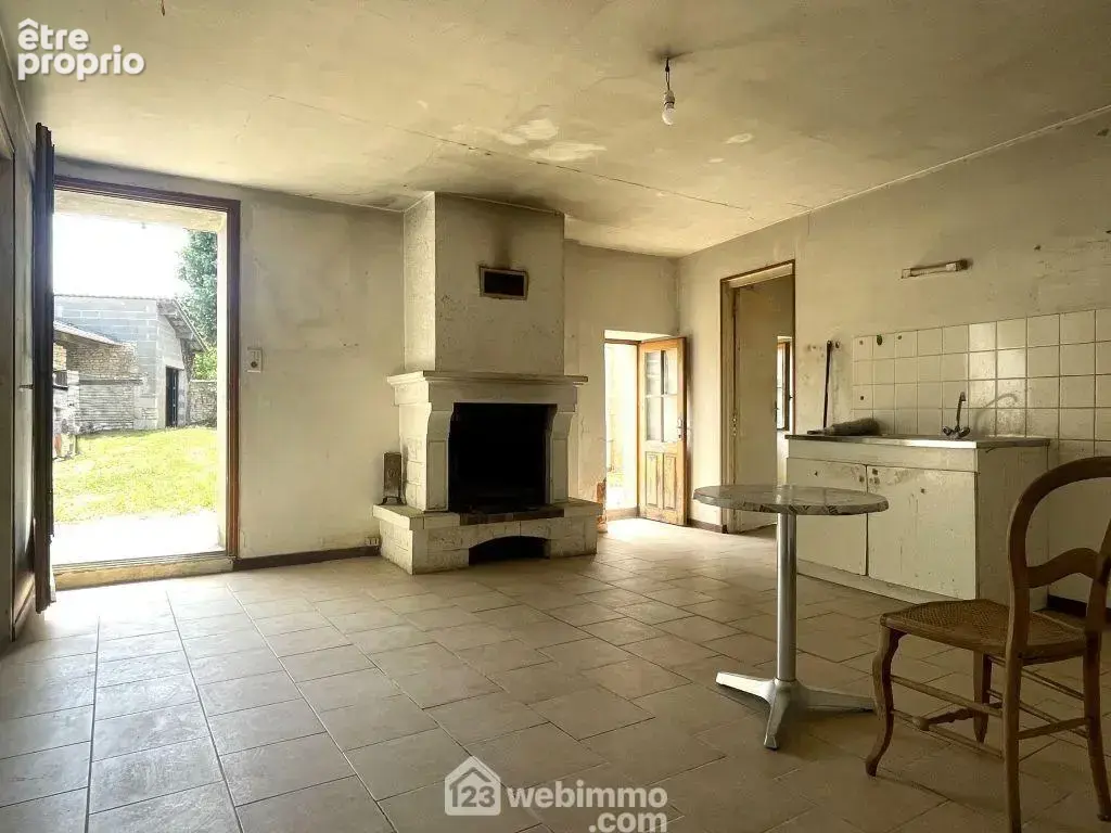 Entrée par la cuisine de 22 m2 avec cheminée.