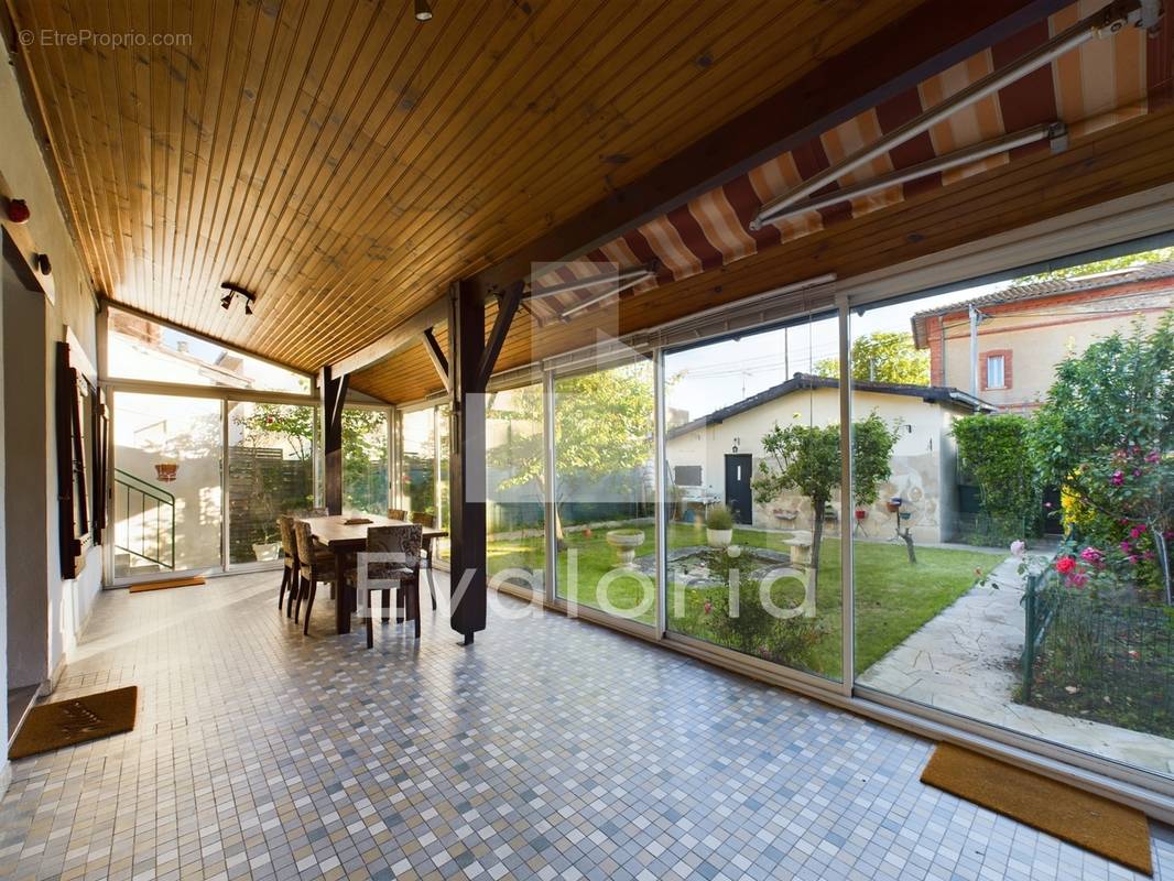 Véranda de 23 m² (non compris dans les 110 m² de la maison) exposée sud-ouest, donnant sur le jardin.