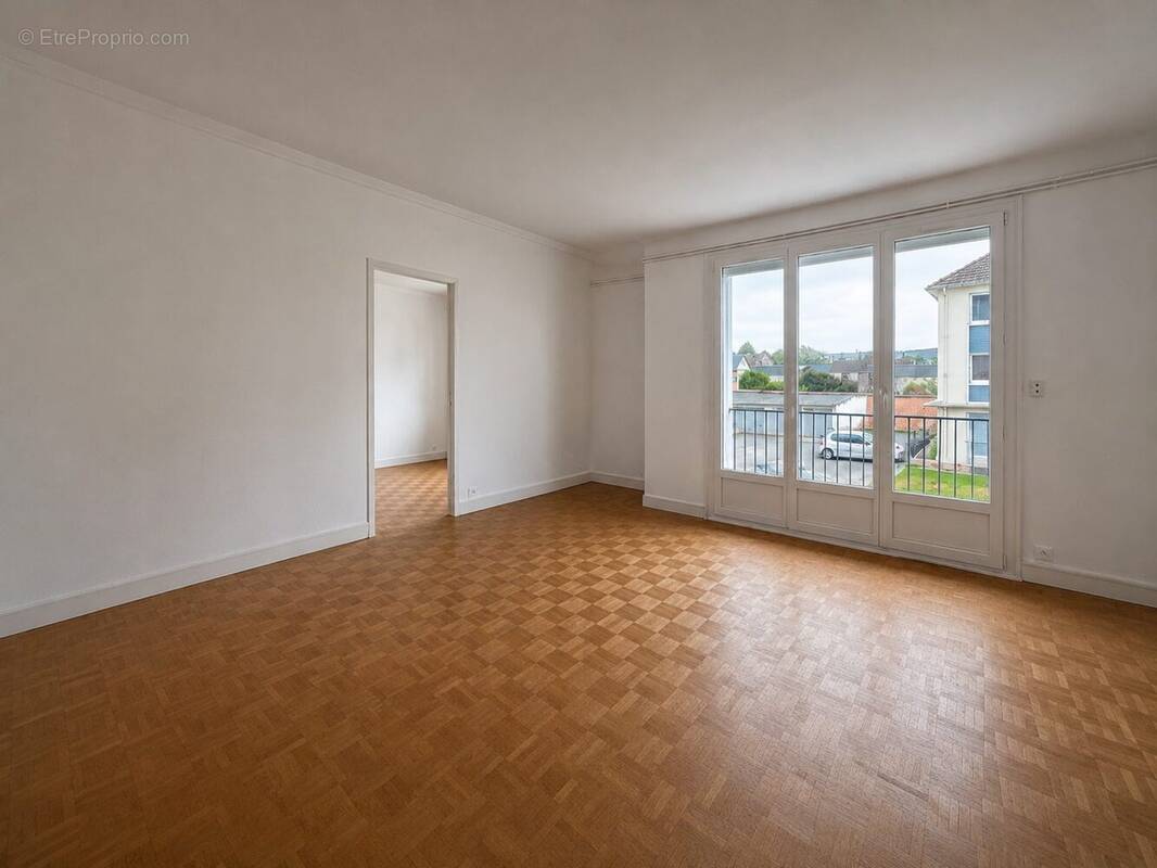 Séjour lumineux avec accès au balcon Une belle pièce de vie baignée de lumière, offrant un espace convivial et agréable au quotidien. - Appartement à LOUVIERS