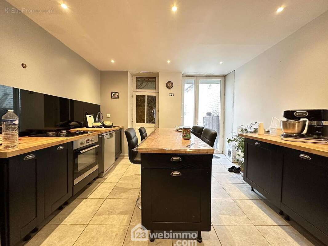 Une cuisine entièrement équipée avec accès sur l'extérieur - Maison à LIESSE-NOTRE-DAME