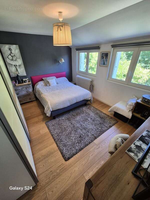 Chambre lumineuse avec parquet, offrant un espace confortable et une vue dégagée sur l'extérieur. - Maison à LAVAL