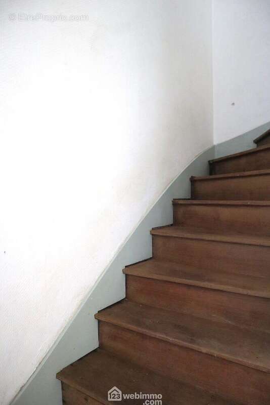 Depuis l&#039;entrée, un escalier en bois mène à l&#039;étage. - Maison à CHAUVIGNY