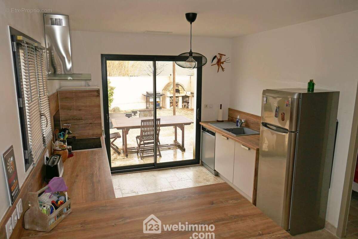 La cuisine aménagée et équipée donne sur la terrasse pergola - Maison à ARLES