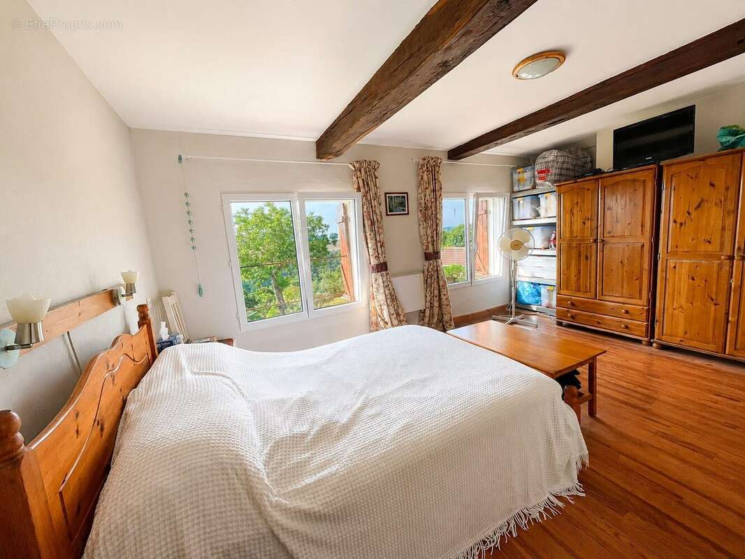 Bright bedroom with wooden floor and exposed beam in Pallanne - Maison à MARCIAC