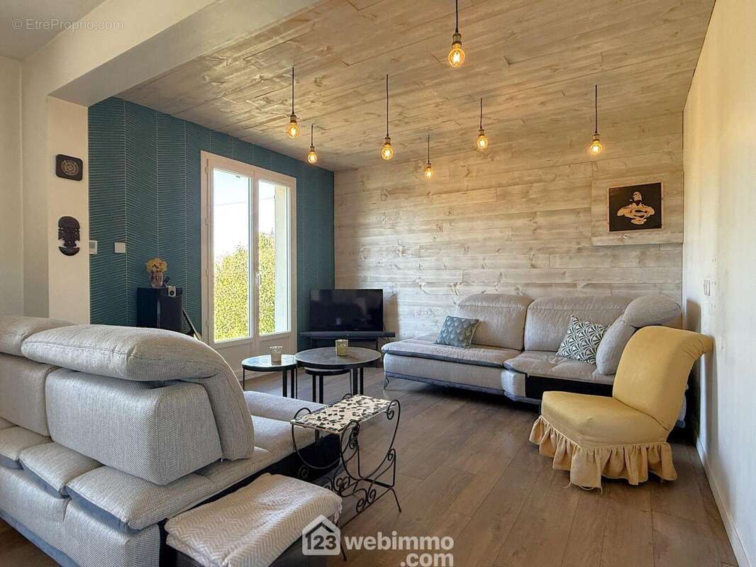 Un espace salon, - Maison à MIGNE-AUXANCES