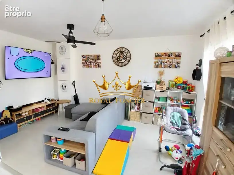 Salon avec sa baie vitrée avec accès sur la terrasse 