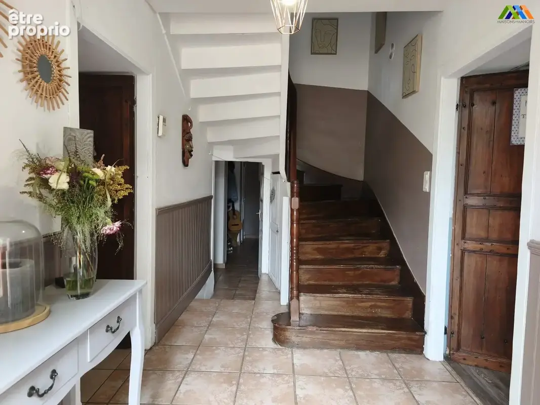 Entrée et escalier en bois desservant les espaces de vie de la maison